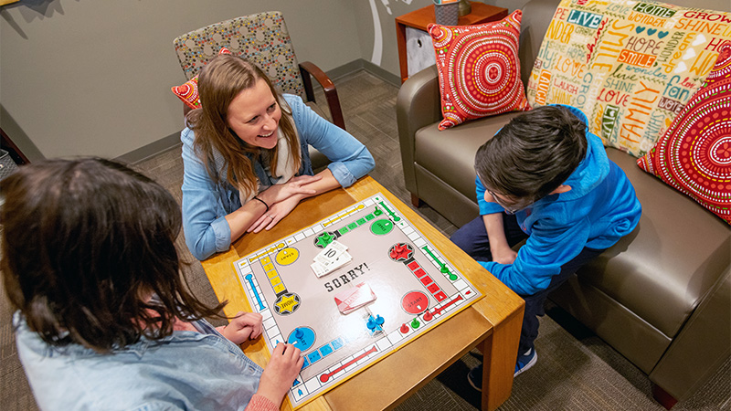 Kids and therapist playing board game